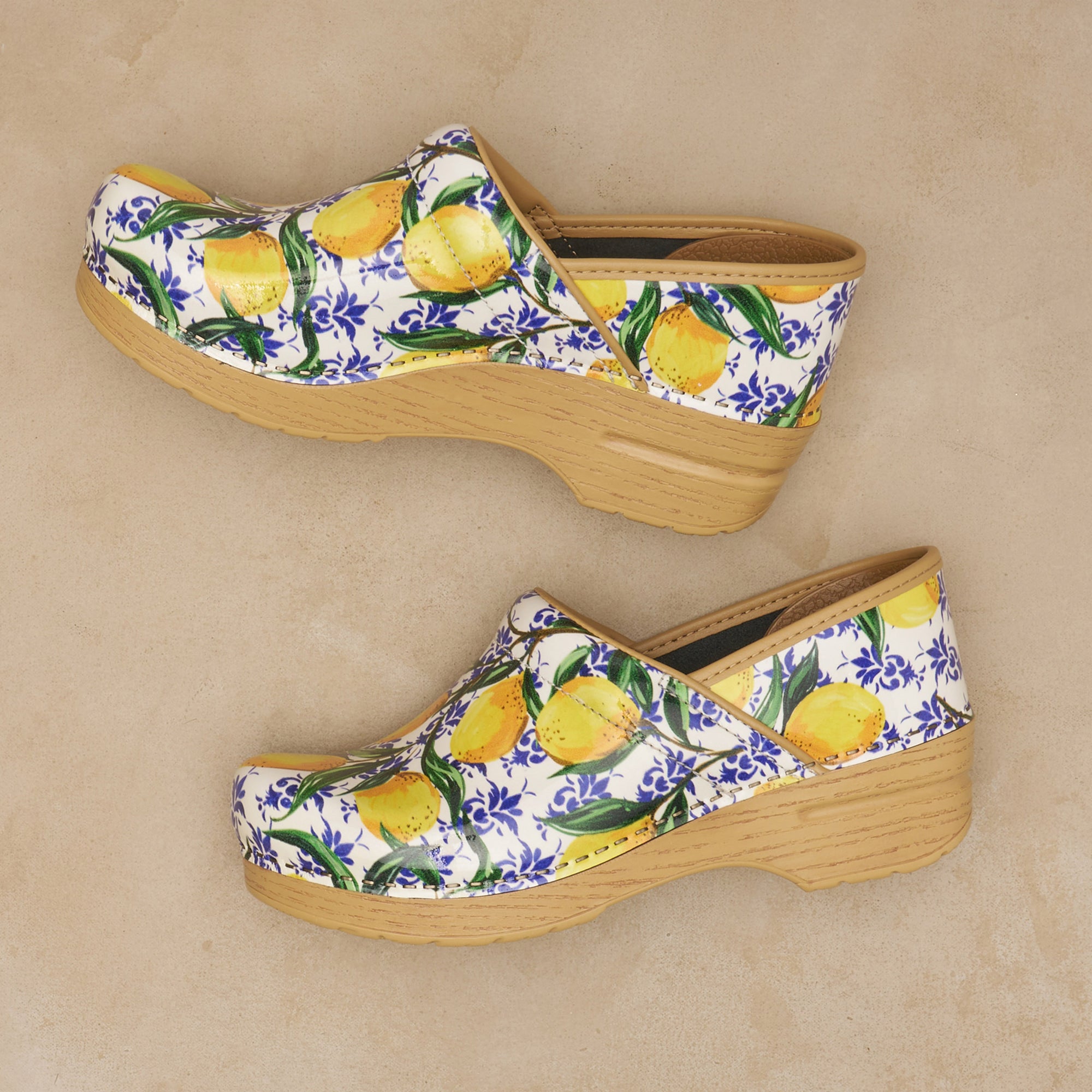 Close up of lemon clogs on neutral backdrop.