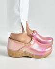 Close up of pink iridescent clogs with white backdrop.