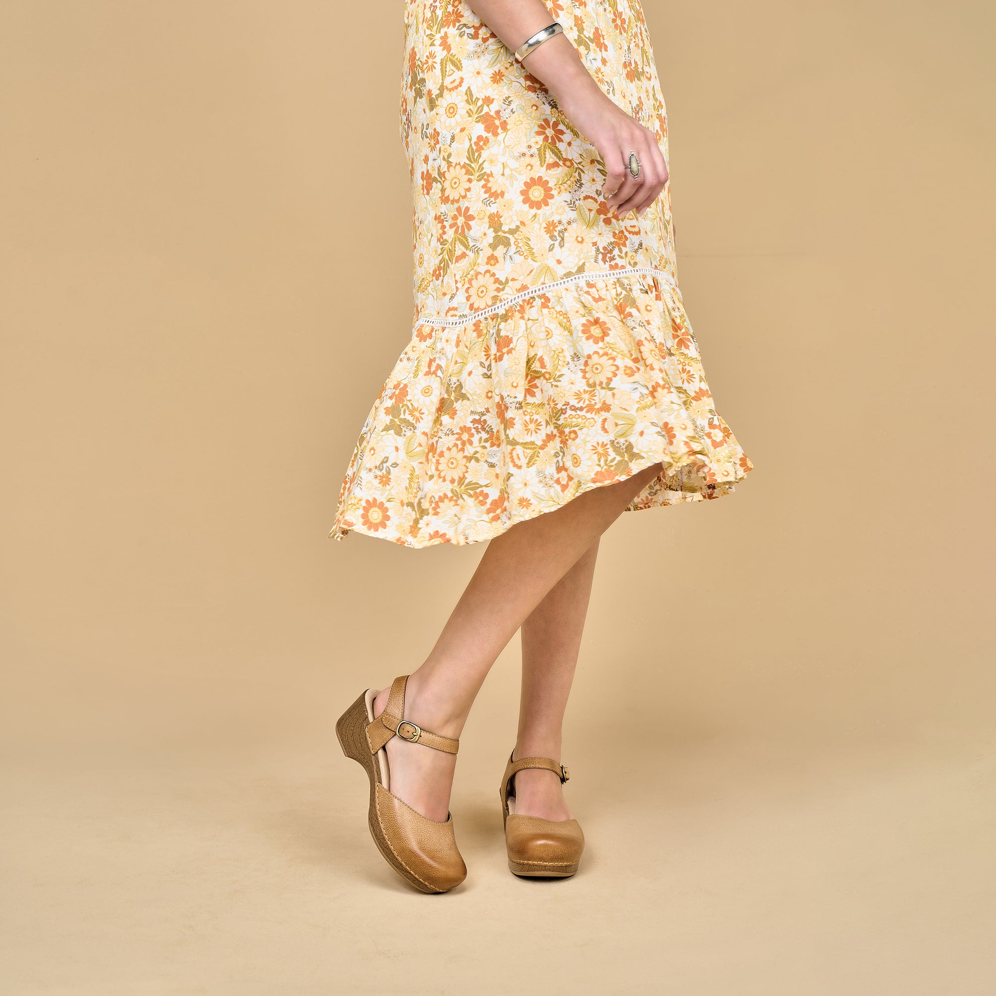 Tan Mary Jane sandals shown on foot with a flowery dress.