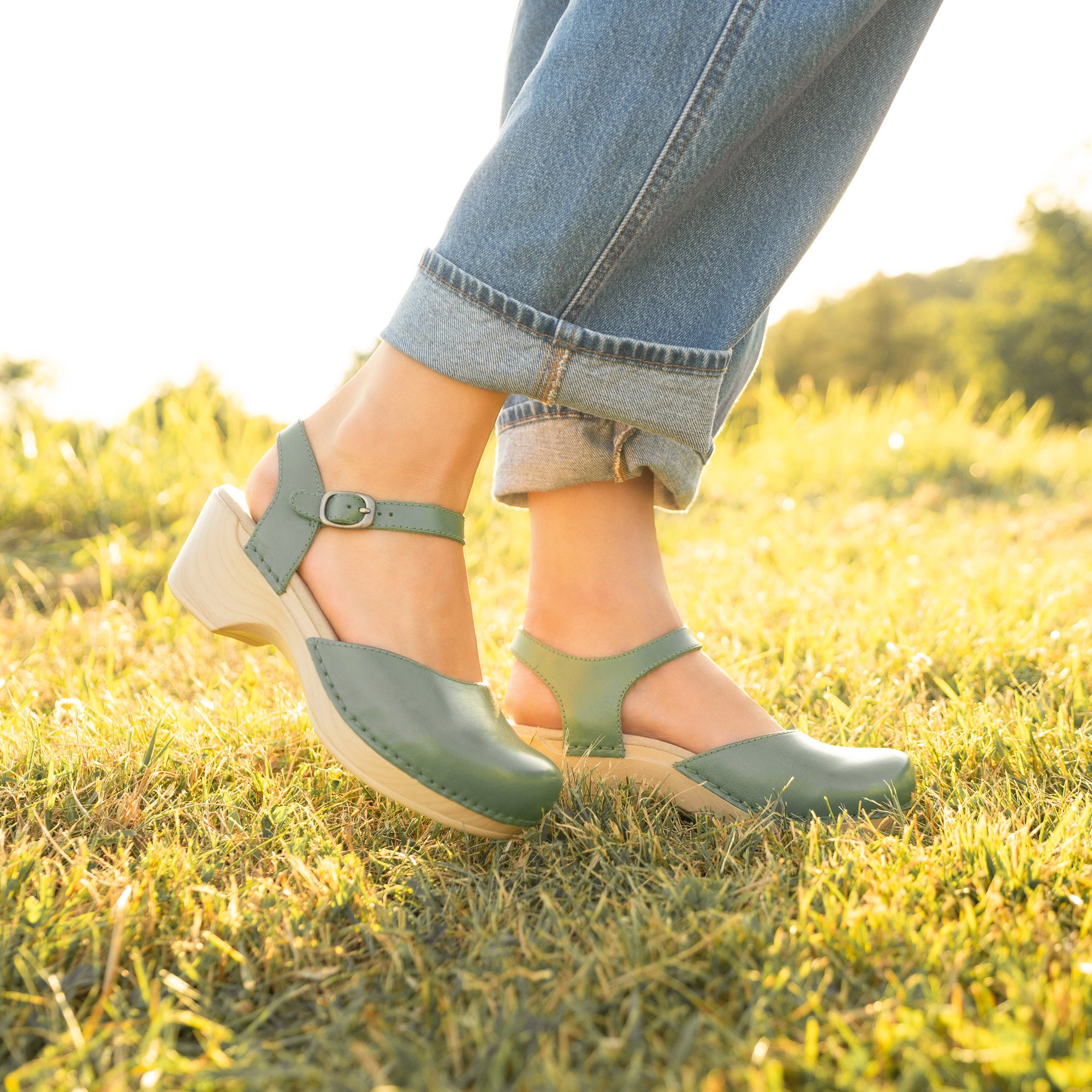 A close up look of pale green flatform sandals shown on foot.