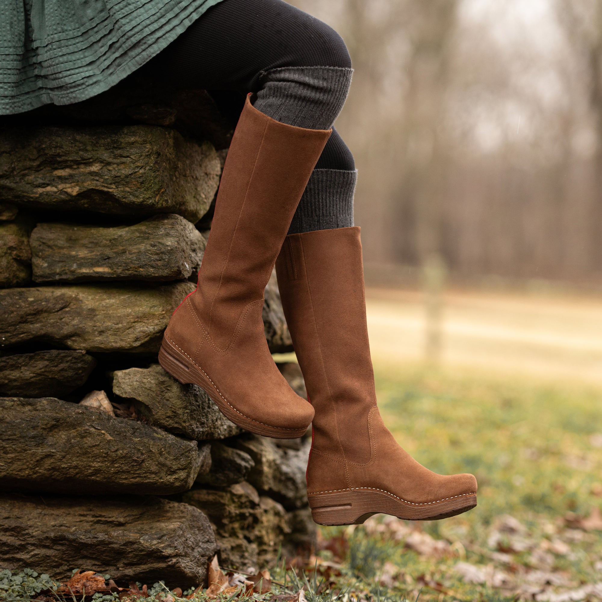 An on-foot look at brown tall-shaft boots with a rocker bottom.