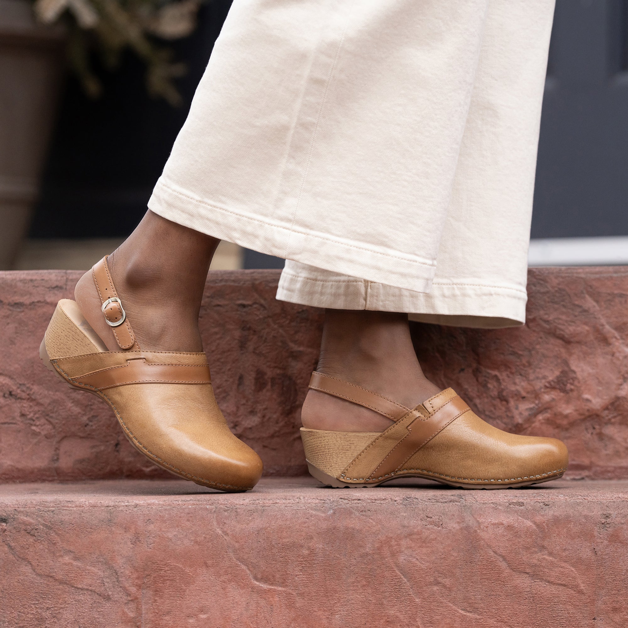 An on-foot look at tan mule clogs with a heel strap.