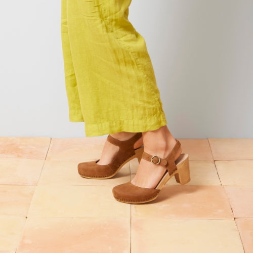 A close up of a brown transitional sandal with a blonde sole and multi-inch heel.