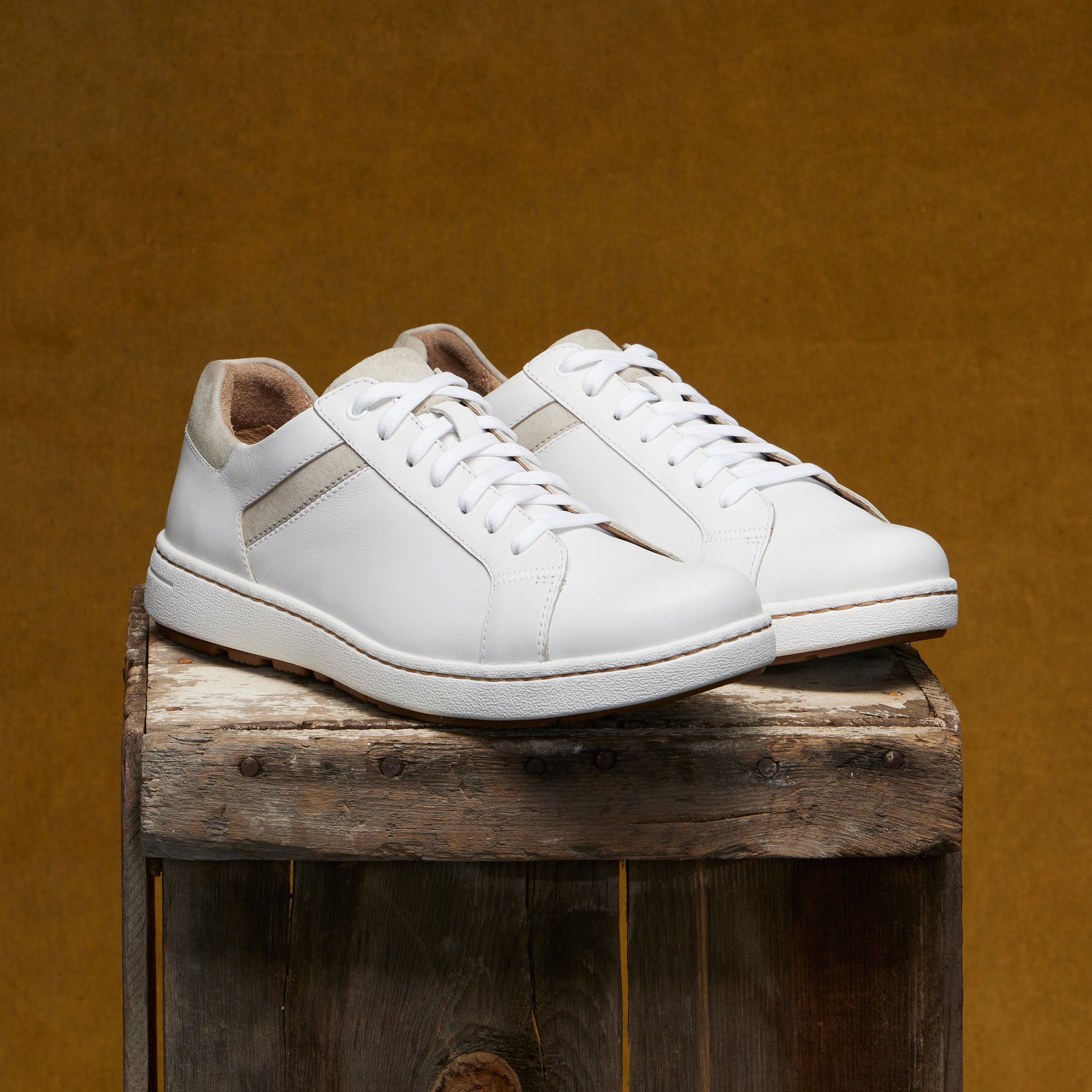 White leather sneakers with tan accents for a stylish casual option.