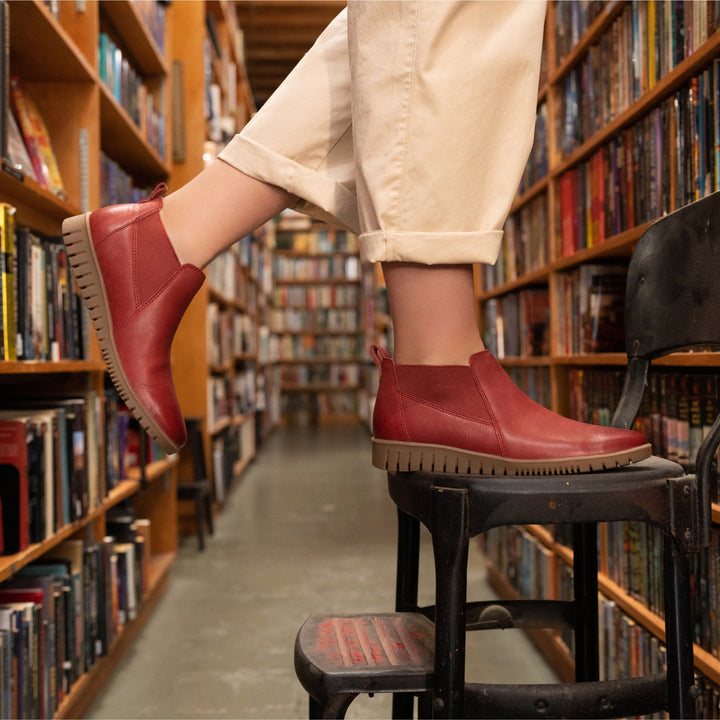 Standing on a stool in supportive, comfortable boots. Red boots provide a subtle color pop.