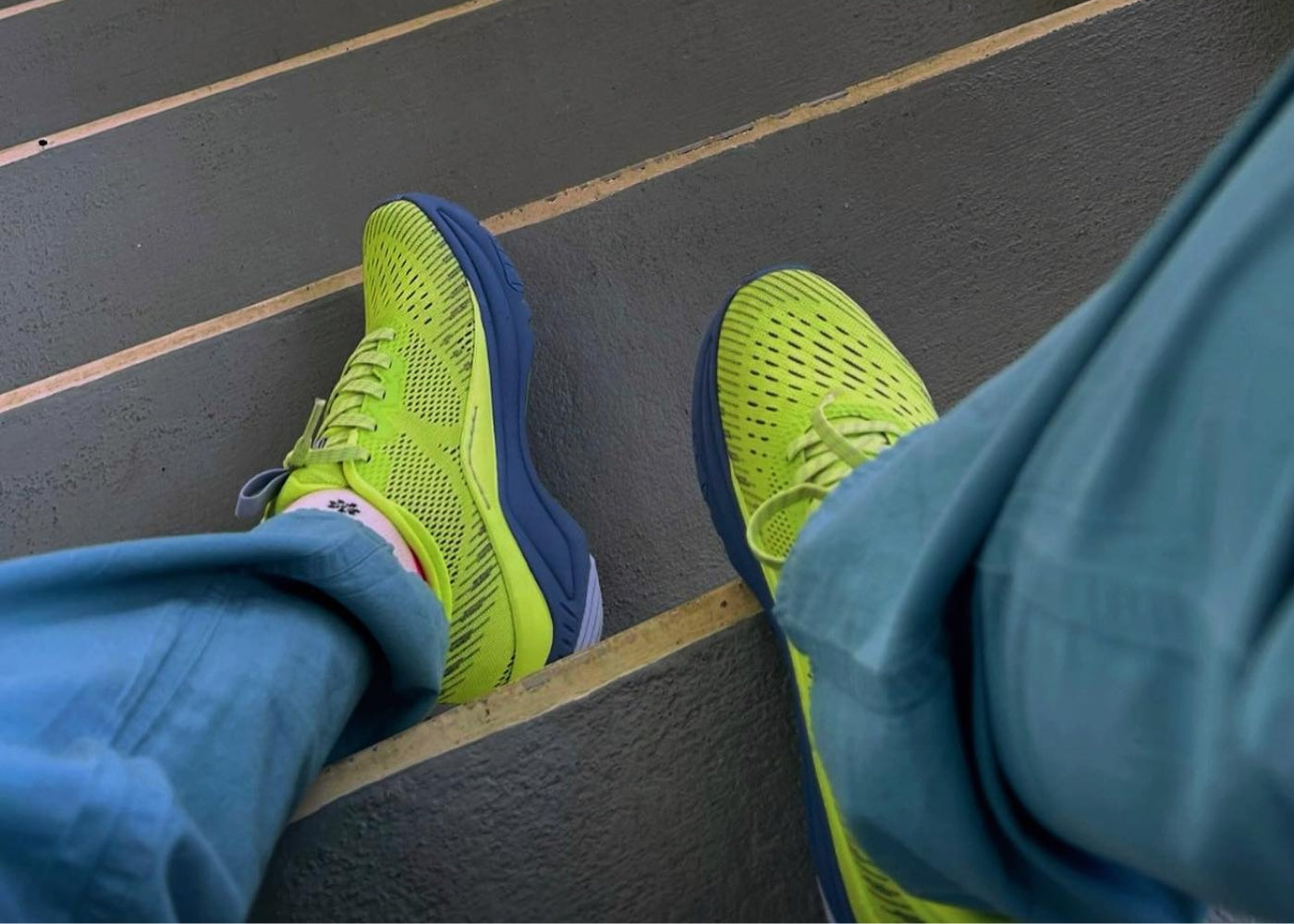 User generated content of healthcare professional showing off bright yellow sneakers on a staircase.