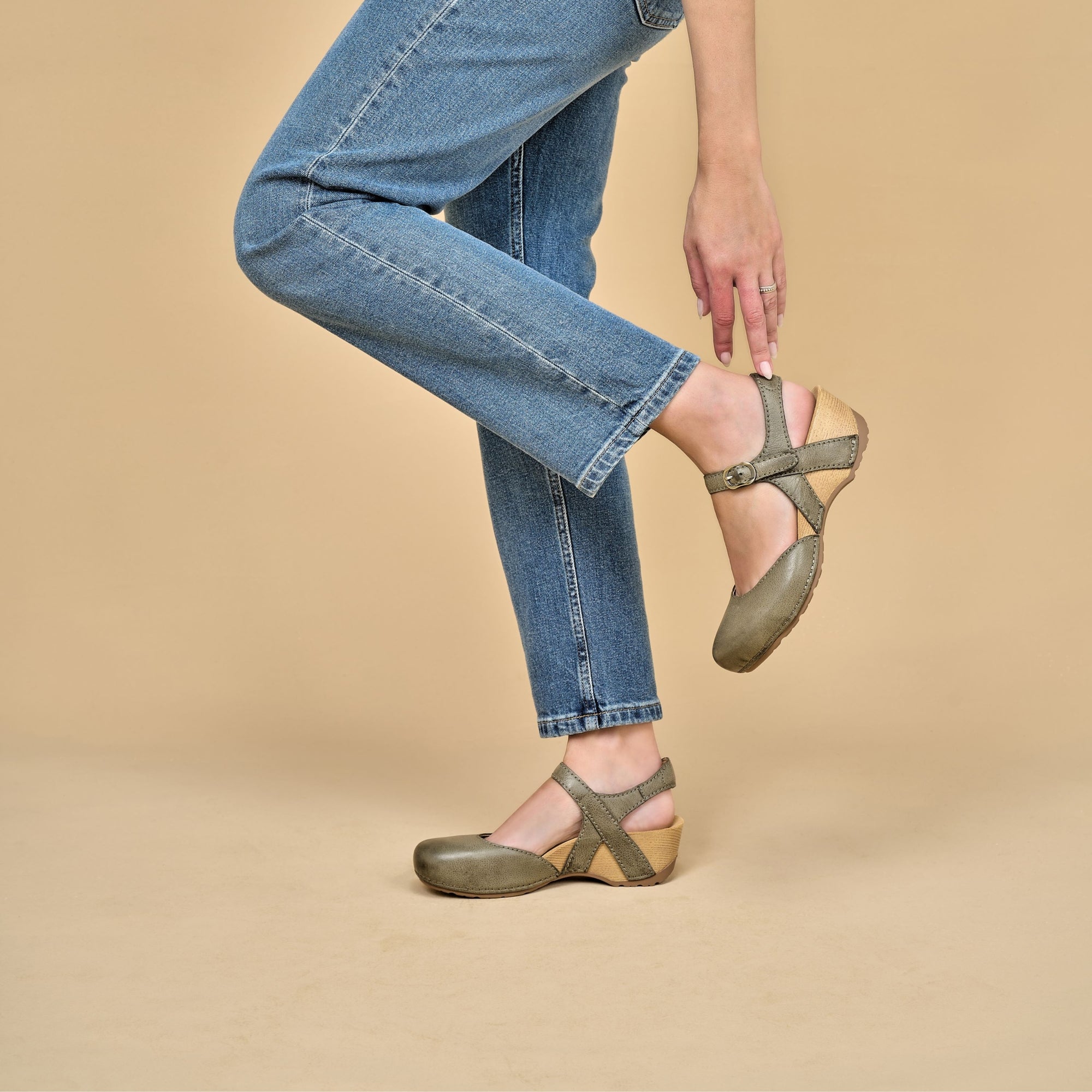 A closeup of green transitional flatform sandals with an adjustable strap shown on foot.
